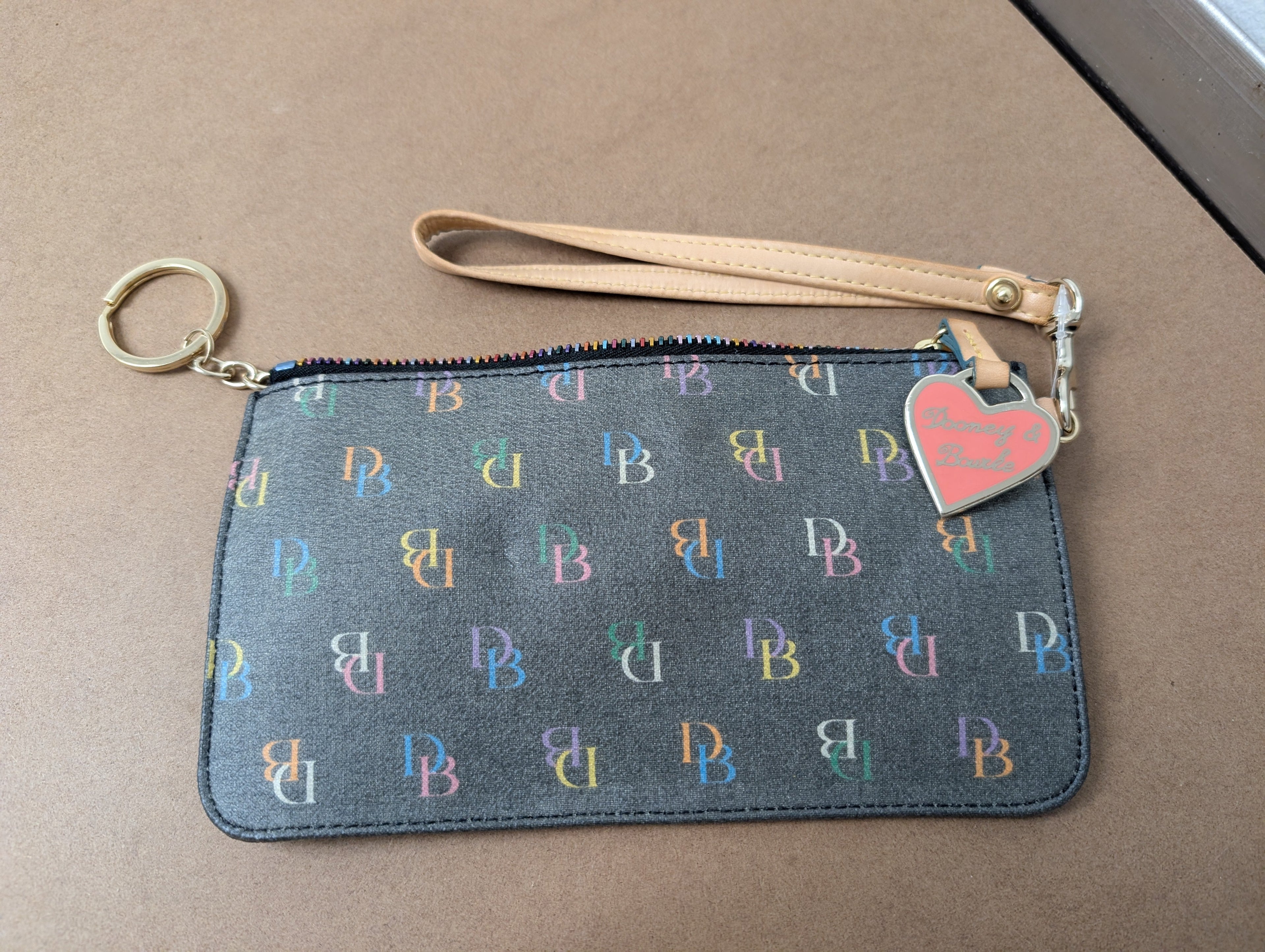 Dooney & Bourke monogram wristlet featuring iconic rainbow zipper and heart charm