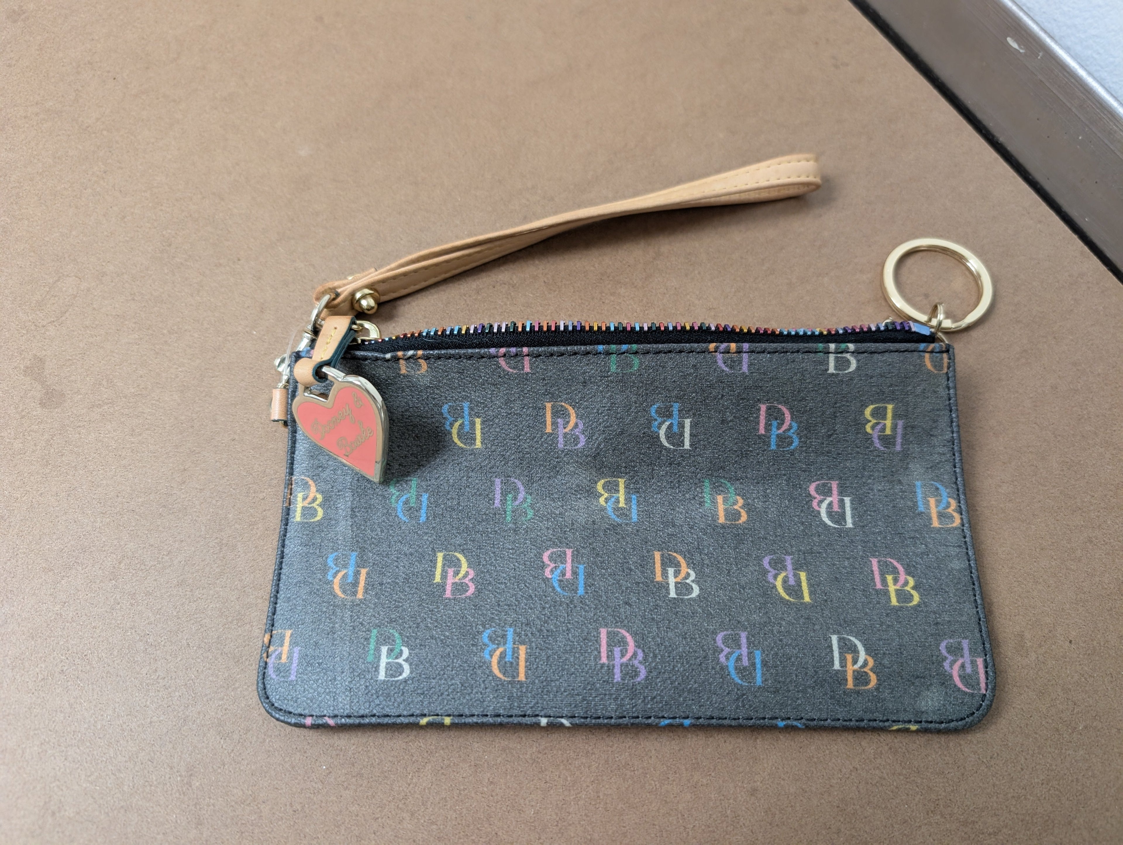 Dooney & Bourke monogram wristlet featuring iconic rainbow zipper and heart charm
