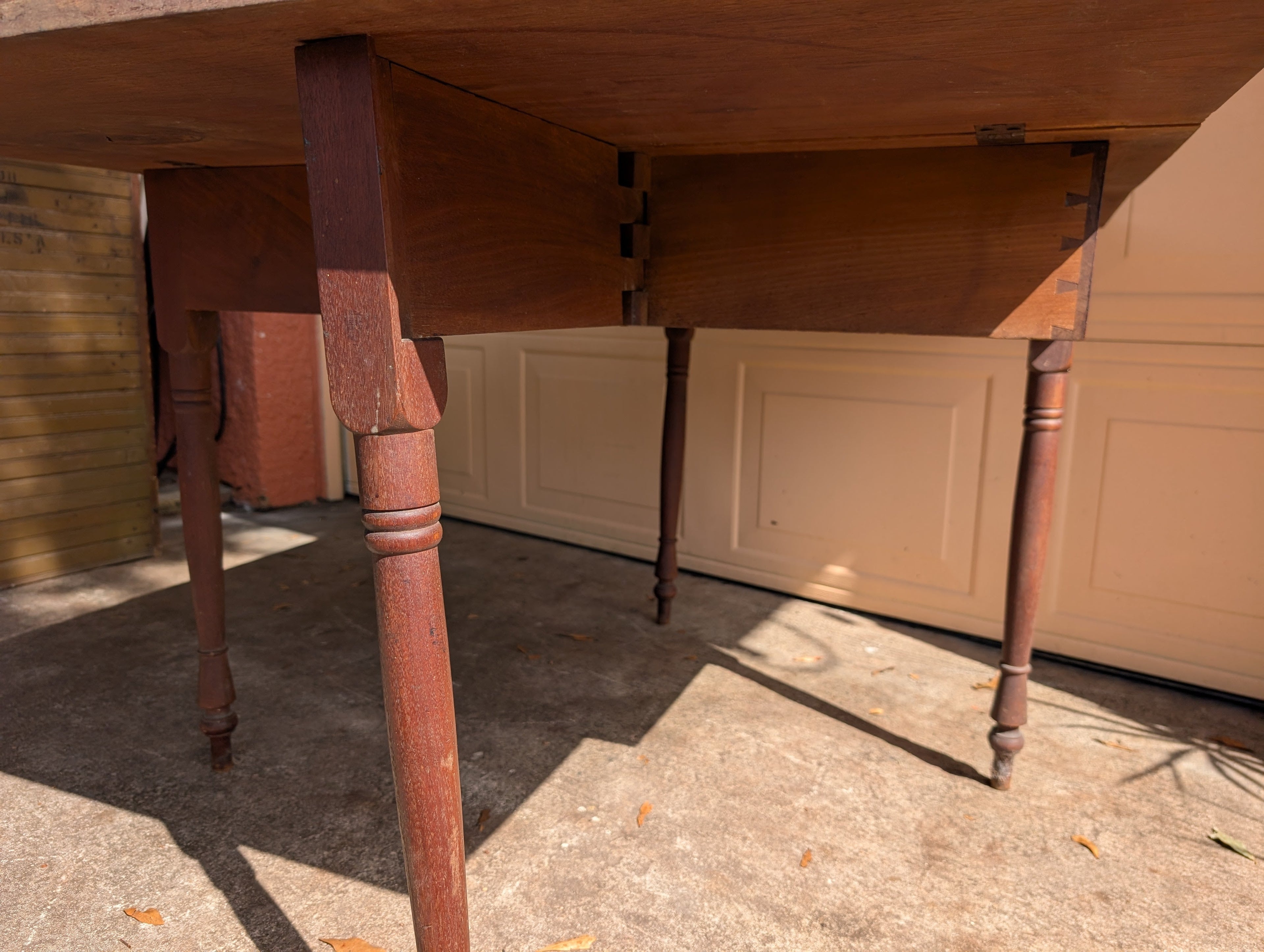 Antique wooden dining table with folding leaves